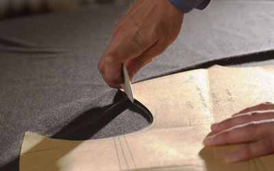 a tailor chalking out a bespoke suit